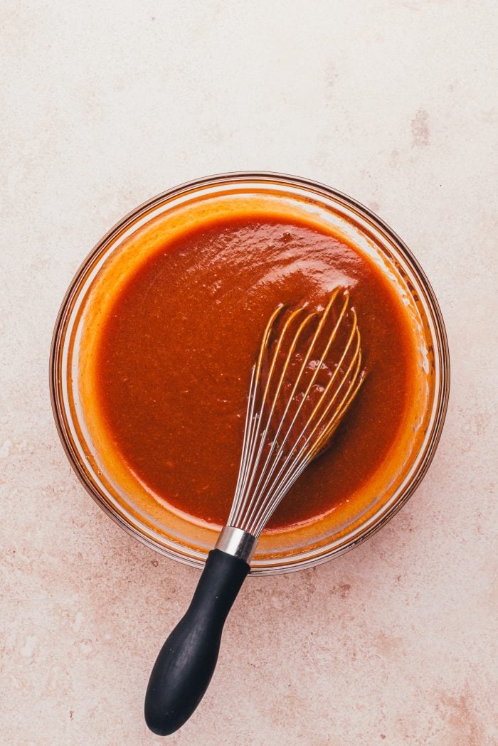 A glass bowl with pumpkin puree and the other wet ingredients.
