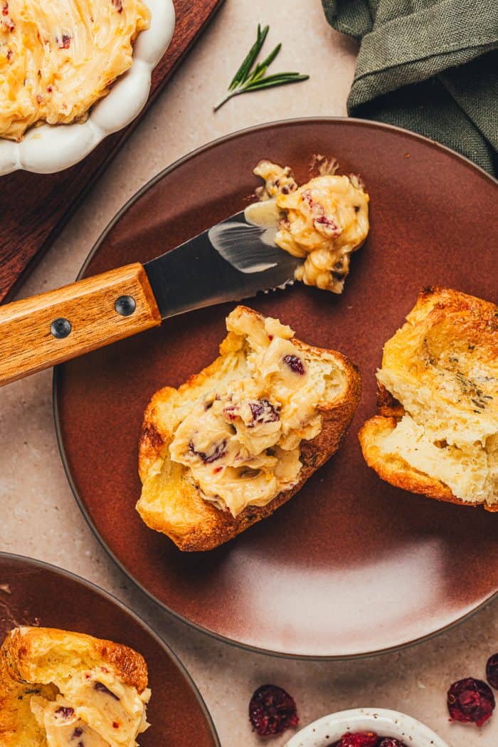 A rosemary popovers smothered with cranberry butter on a plate.