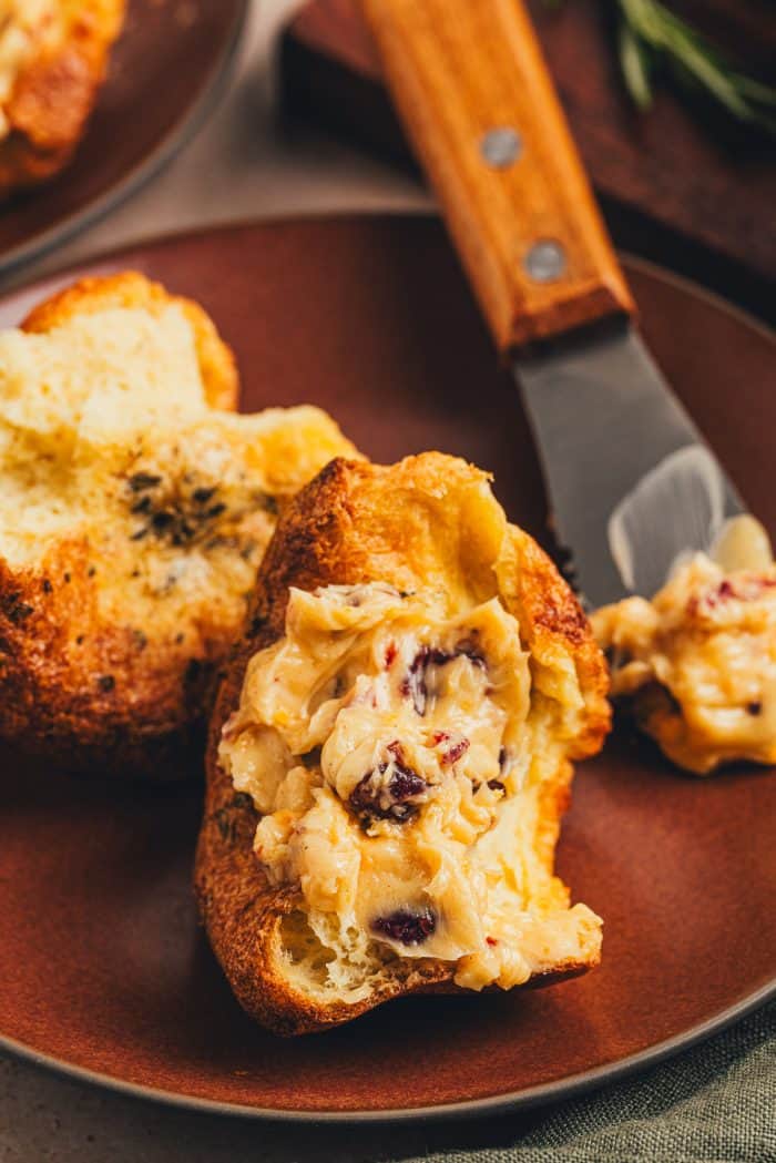 A rosemary popovers smothered with cranberry butter on a plate.