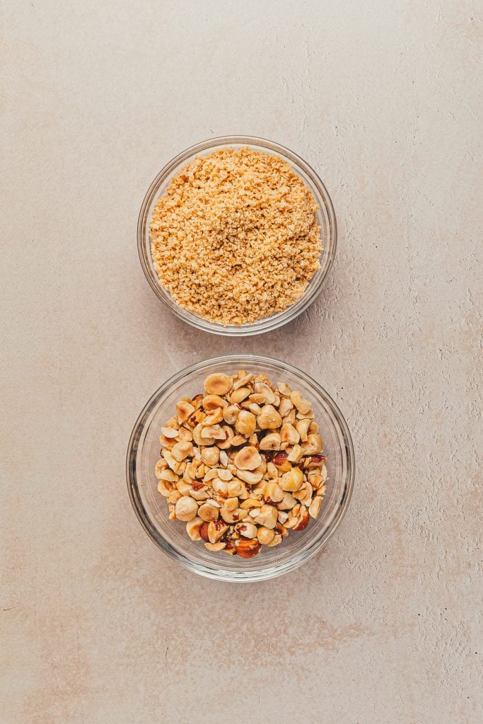 Two bowls of chopped hazelnuts. One bowl is roughly chopped and one is finely chopped.