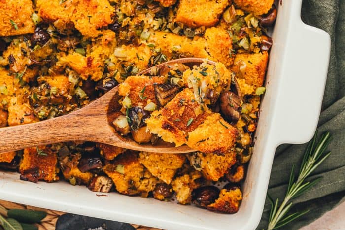 A spoonful of stuffing being lifted out of the baking dish.