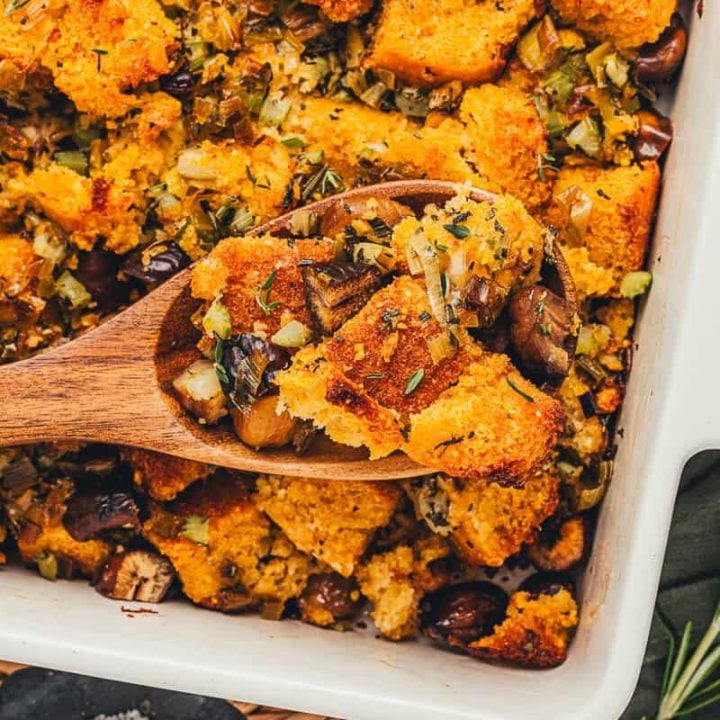 A spoonful of stuffing being lifted out of the baking dish.