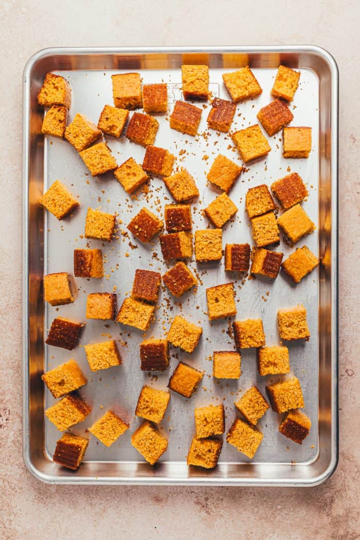 Cornbread cubes on a baking sheet.