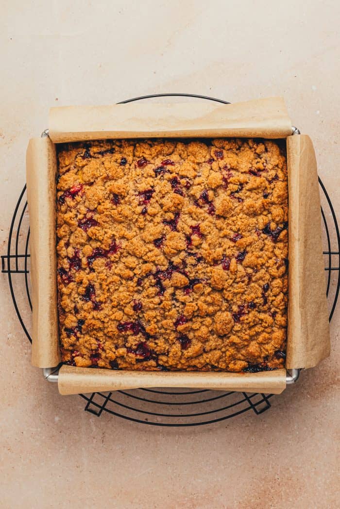 The baked cranberry crumb cake cooling on a cooling rack.