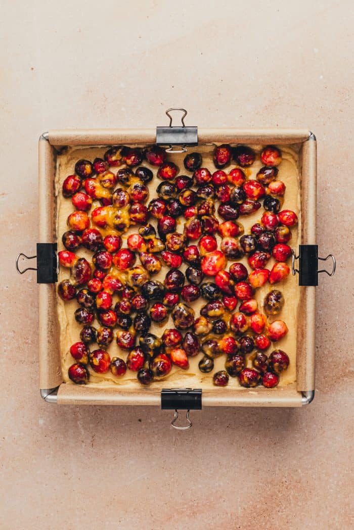 A baking pan with the cranberry and unbaked cake layer in it.