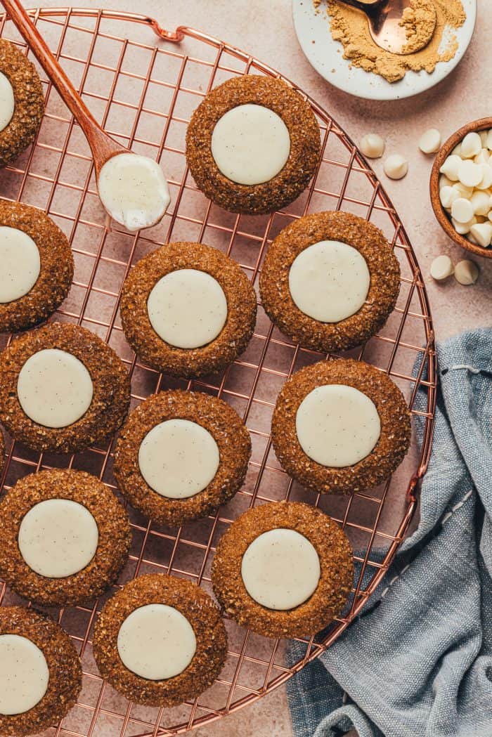 A variety of gingerbread thumbprint cookies on a cooling rack. 