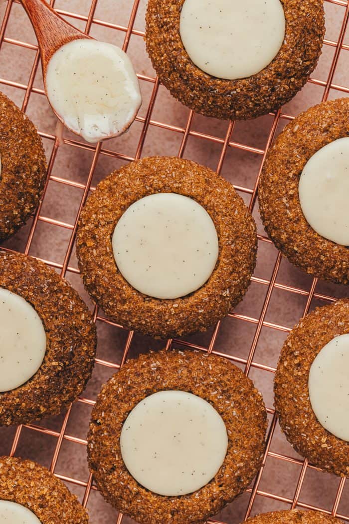 A variety of gingerbread thumbprint cookies on a cooling rack.