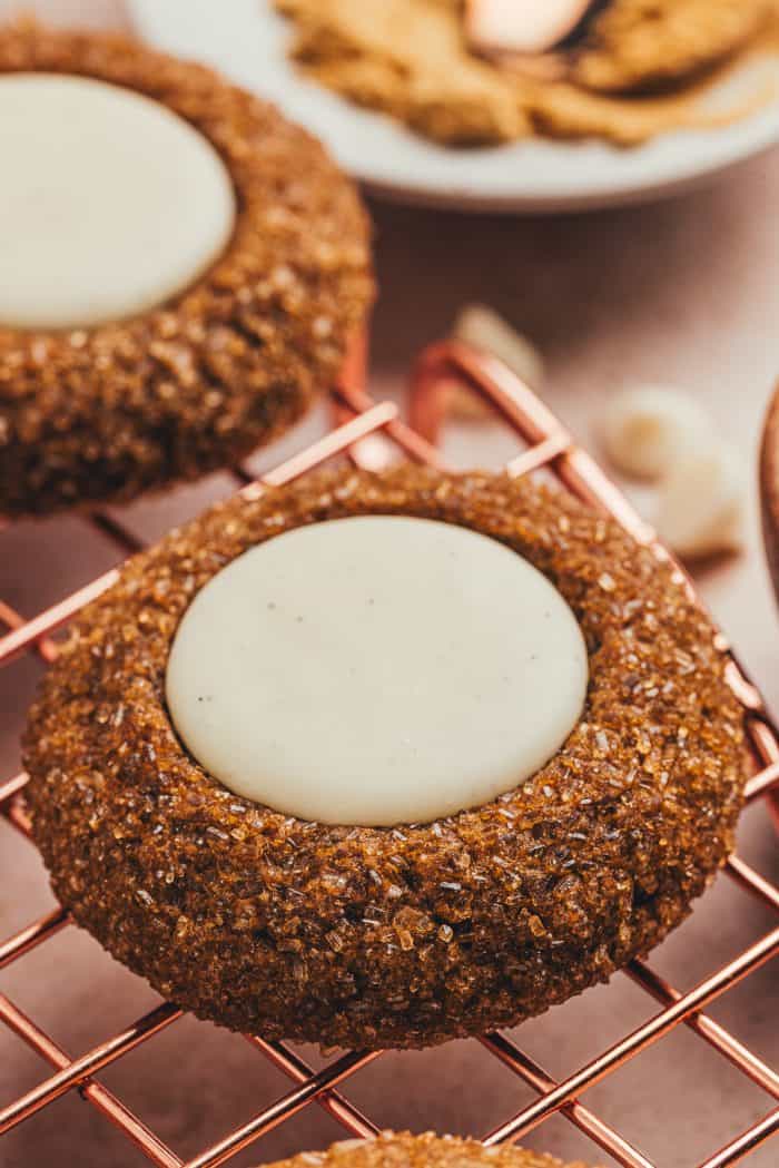 A variety of gingerbread thumbprint cookies on a cooling rack.
