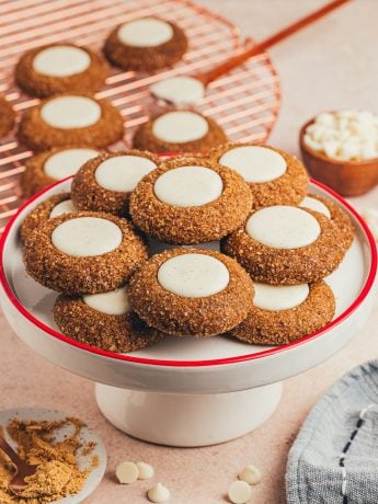 A cake stand with a variety of gingerbread thumbprint cookies.