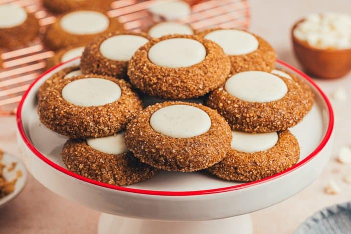 A cake stand with a variety of gingerbread thumbprint cookies.