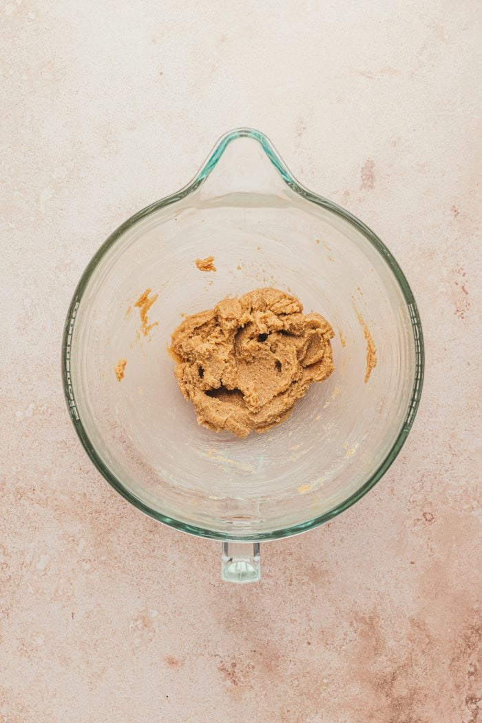 The butter and sugar beat together in a glass bowl.