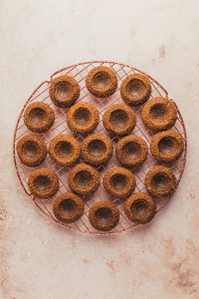 The baked gingerbread thumbprint cookies on a cooling rack.
