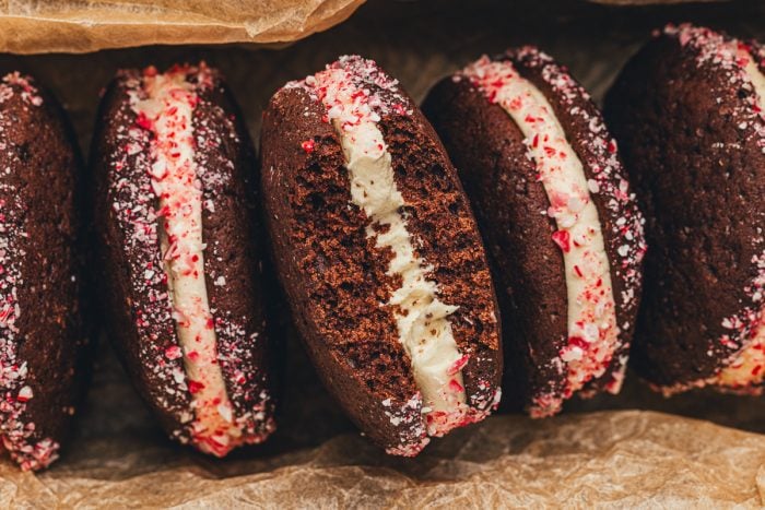 Four chocolate Whoopie pies in a row showing the filling with the crushed peppermints.