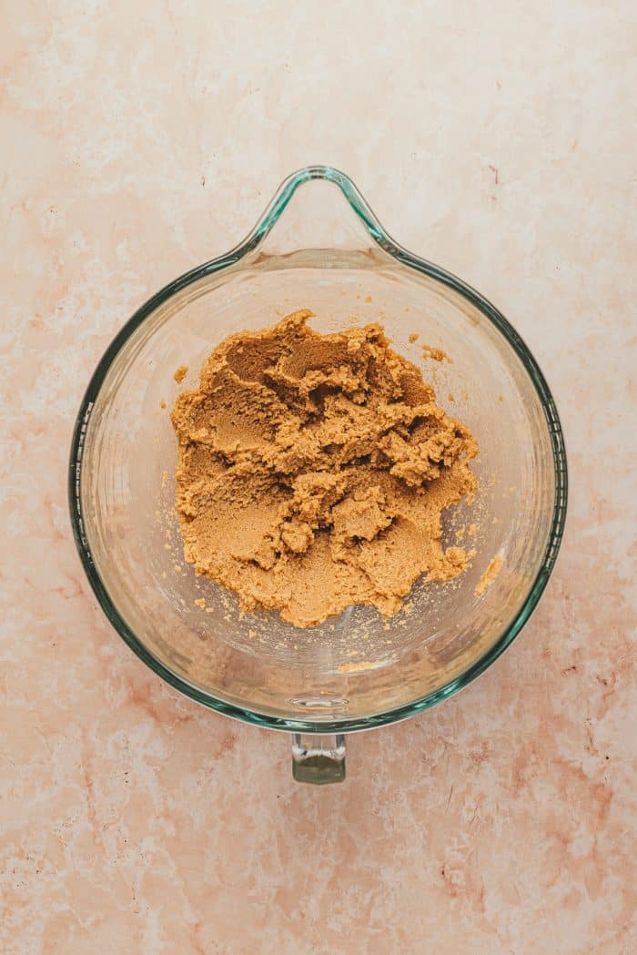 A glass mixing bowl with butter and brown sugar mixed together.