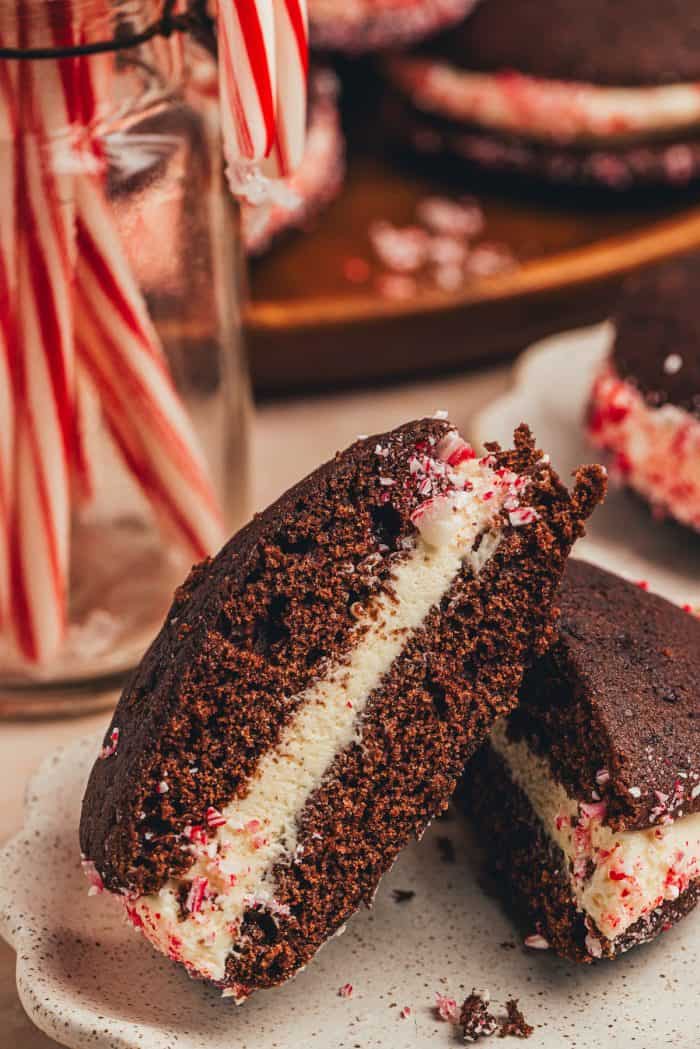 A chocolate Whoopie pie cut in half with candy canes in the background.