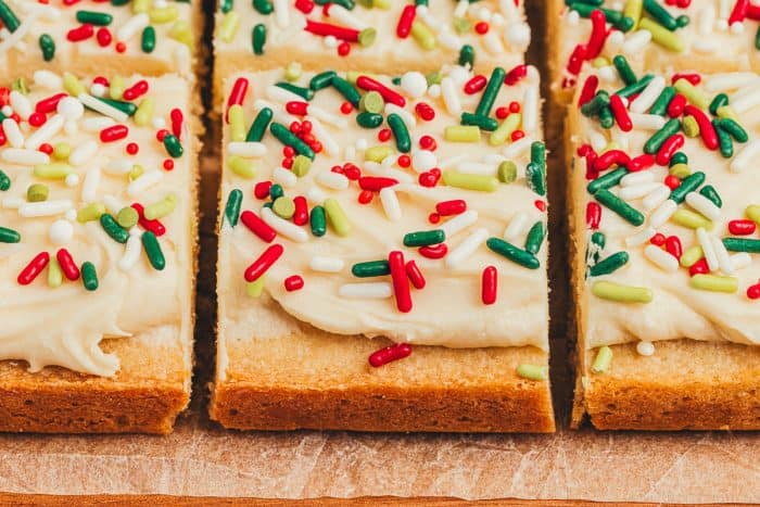 Frosted sugar cookie bars sliced showing the top of the bar with sprinkles.