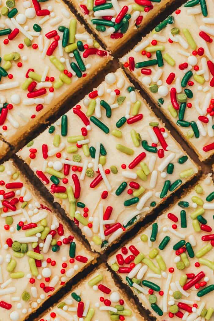 Frosted sugar cookie bars sliced showing the top of the bar with sprinkles.