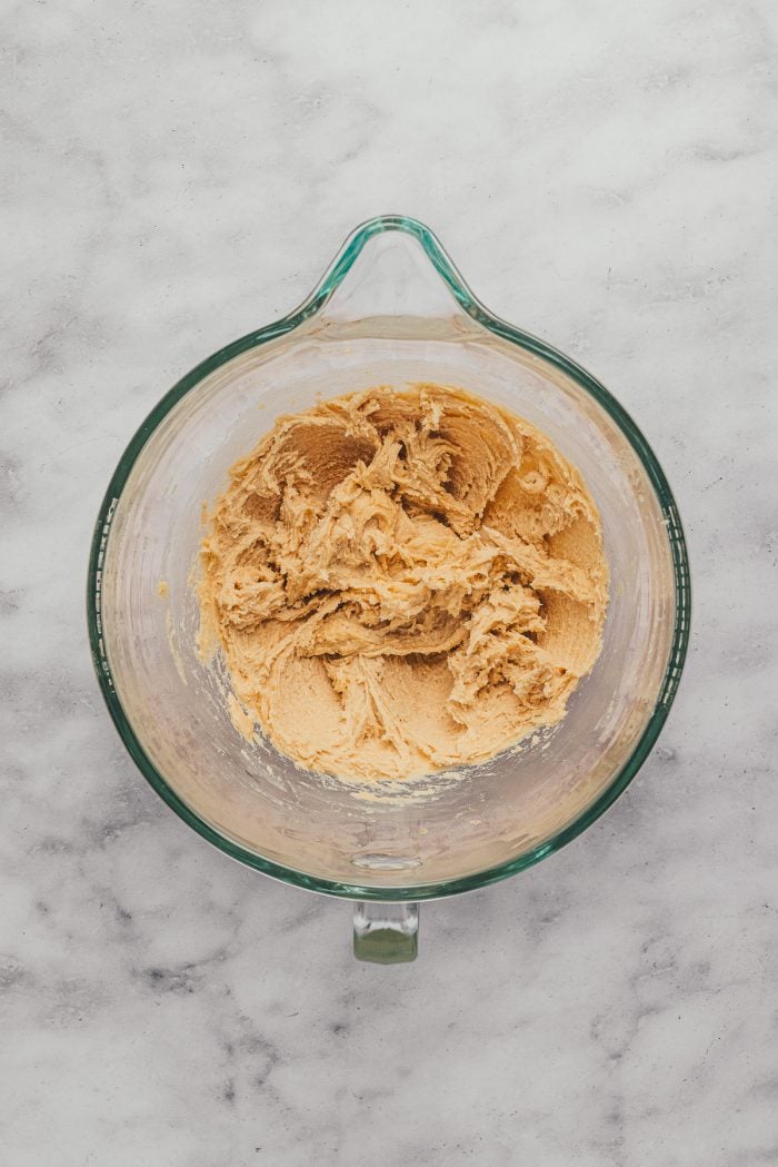 A glass mixing bowl with the batter to make sugar cookie bars.