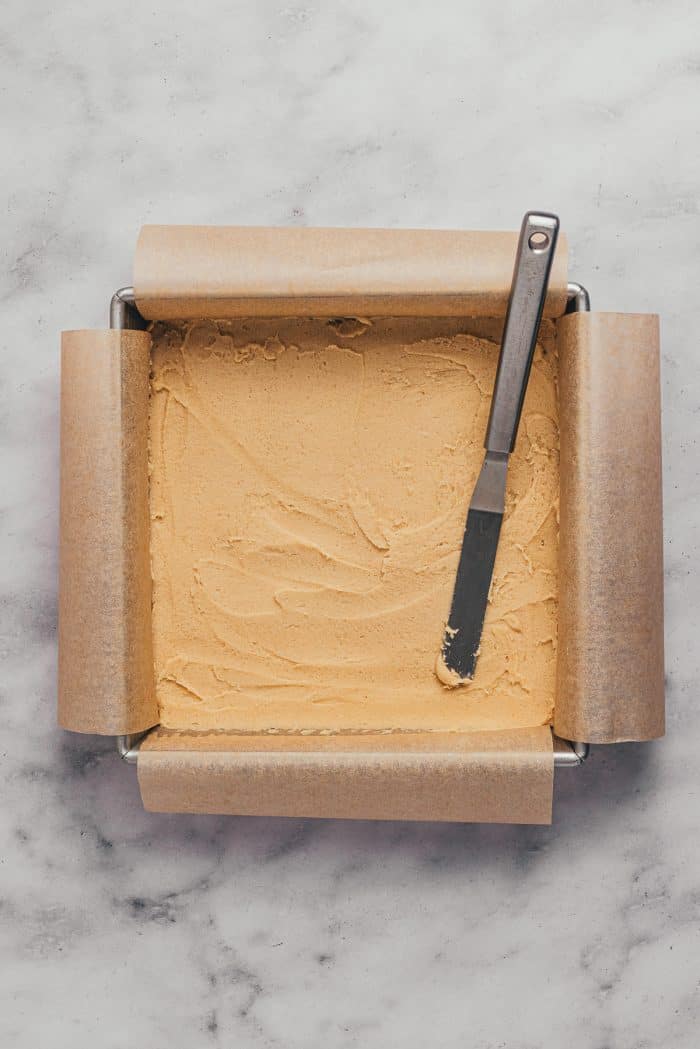 A square baking pan with unbaked sugar cookie bars.