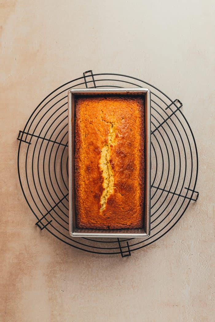 A baked lemon Thyme pound cake on a cooling rack,
