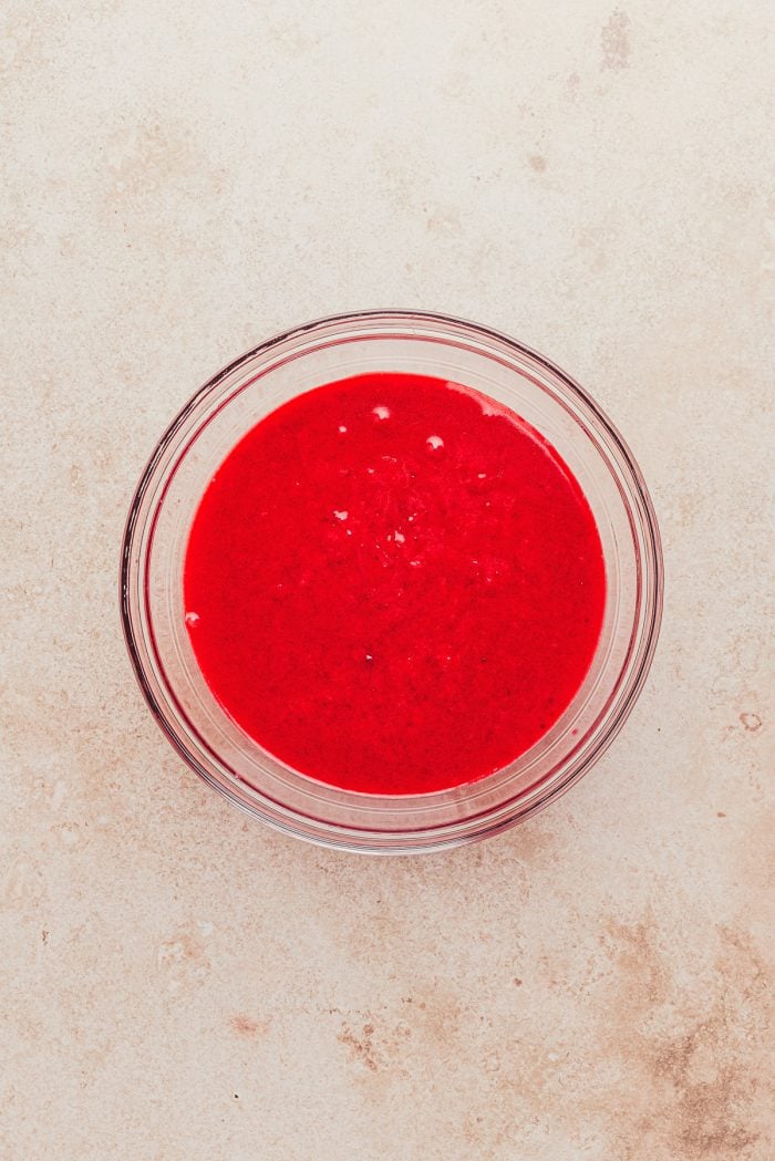 Cranberry curd in a glass mixing bowl.
