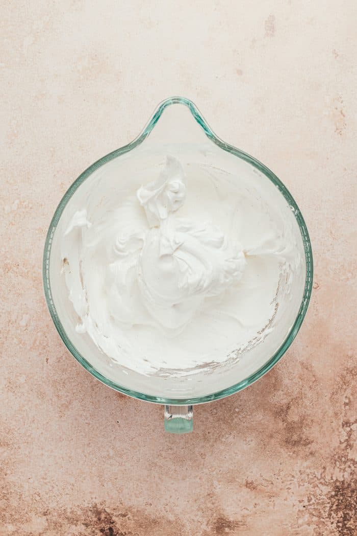 A glass mixing bowl with the mixed pavlova.