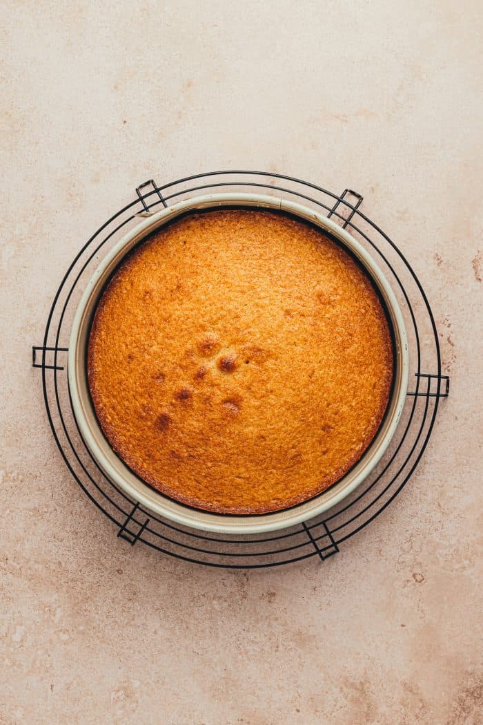 A baked upside down orange cake on a cooling rack.