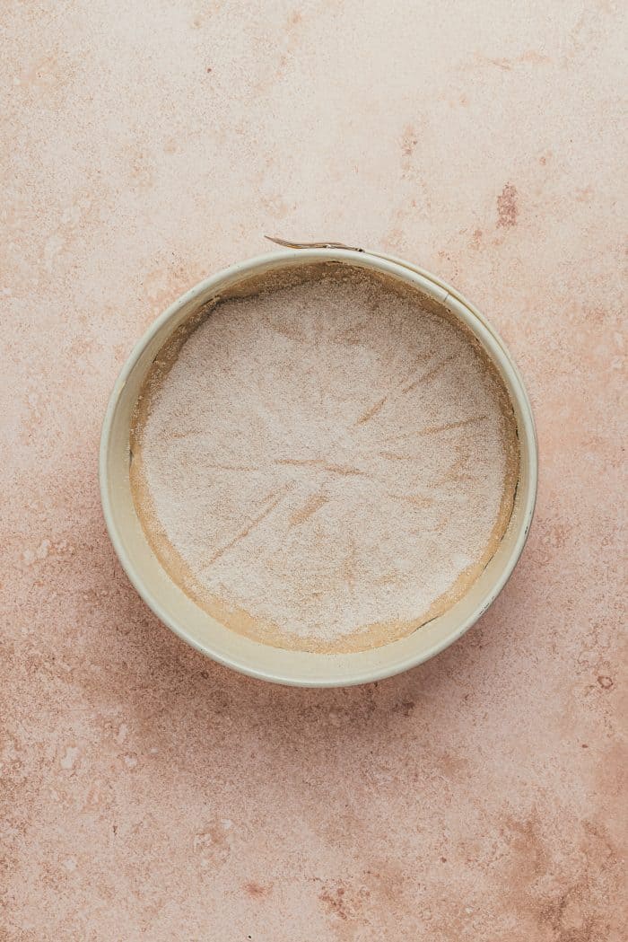 A round cake pan with parchment paper.