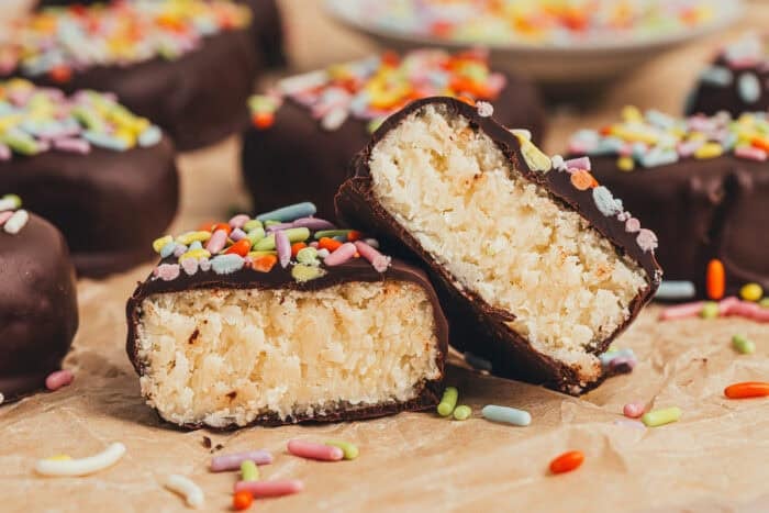 A few homemade chocolate Easter eggs scattered on parchment paper and one egg is split in half. 