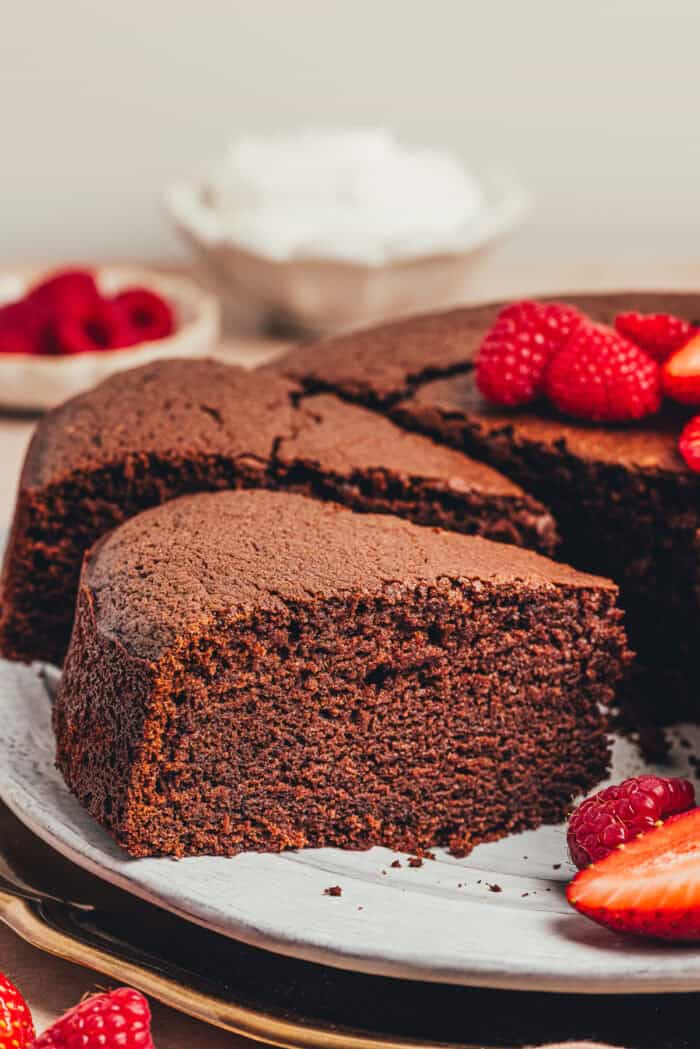 A slice of chocolate ricotta cake being lifted off of a platter.