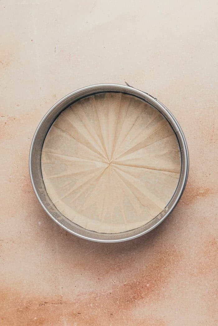 A round metal baking pan with parchment paper.