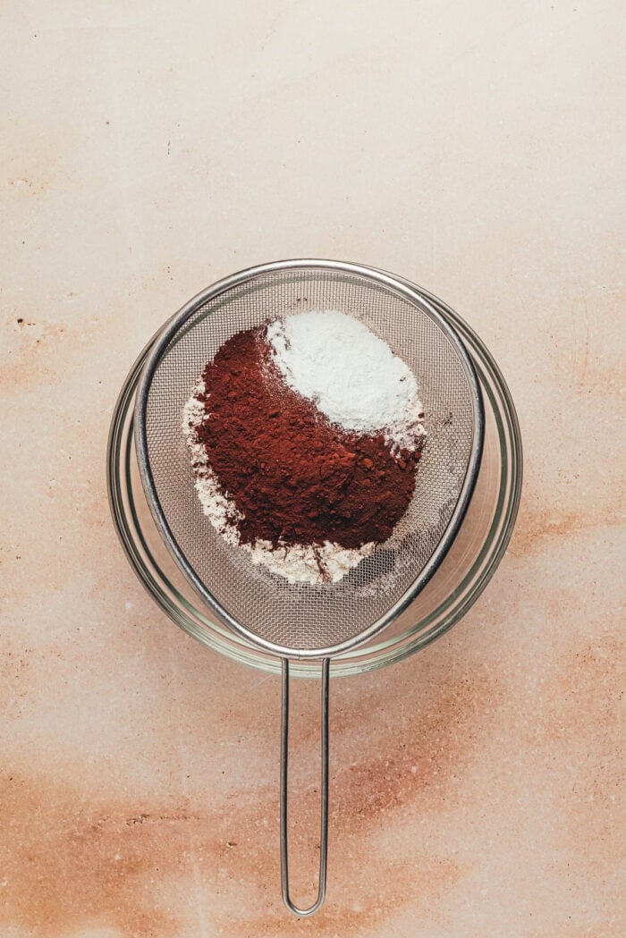 Sifting the dry ingredients into a glass bowl.