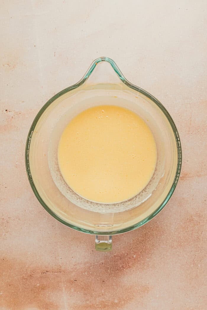 The eggs and ricotta mixed together in a large glass mixing bowl.