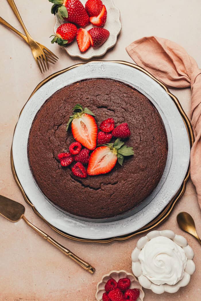 The baked chocolate ricotta cake on a platter with fresh fruit.