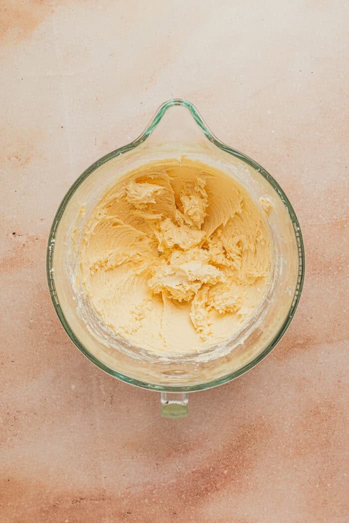 Creamed butter in a glass mixing bowl.