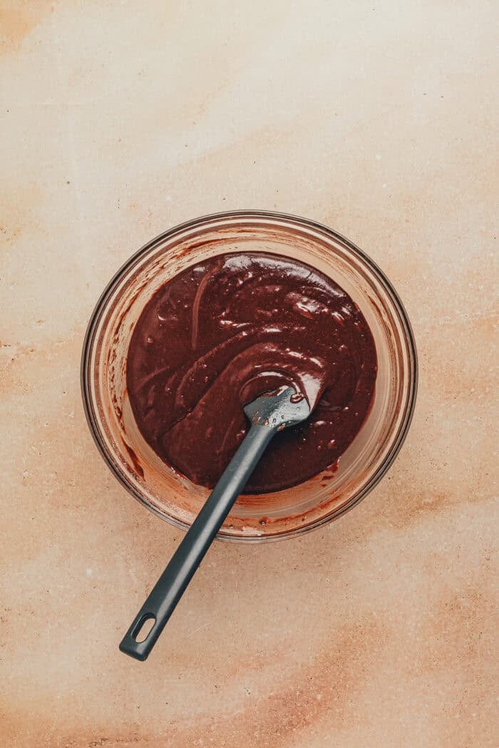 A glass bowl with the cupcake batter for chocolate cupcakes.