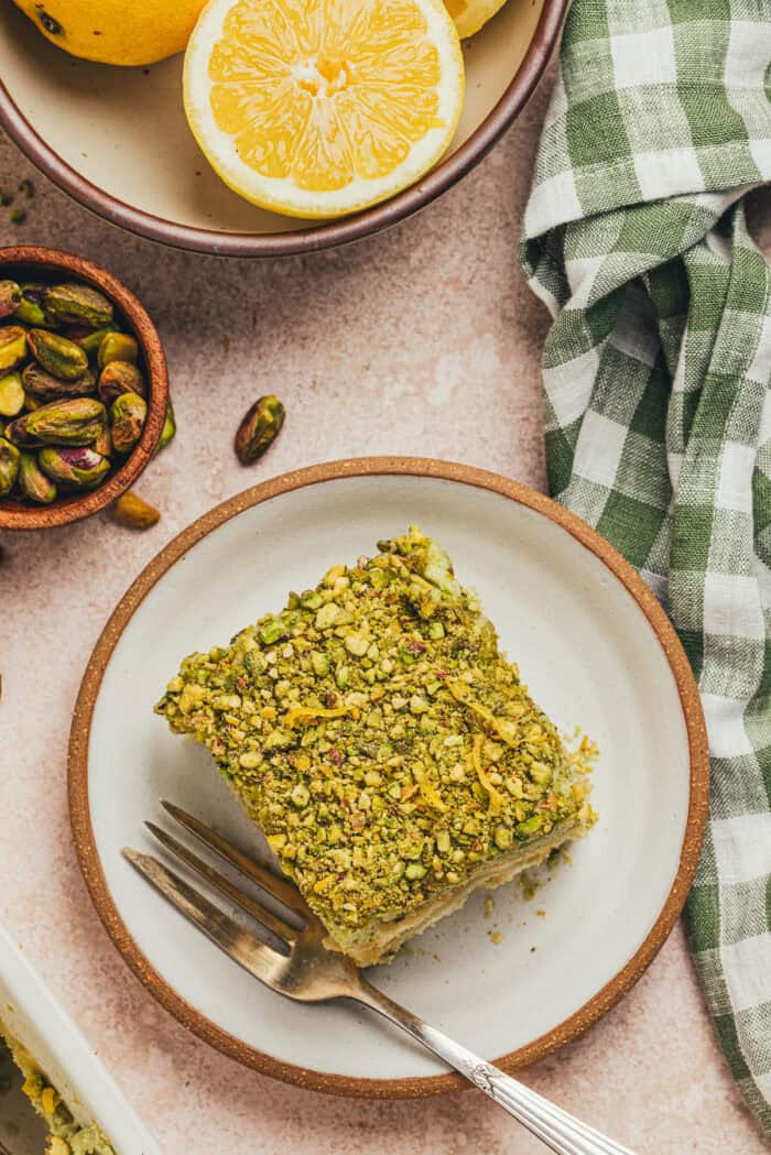 A slice of lemon pistachio tiramisu on a plate.