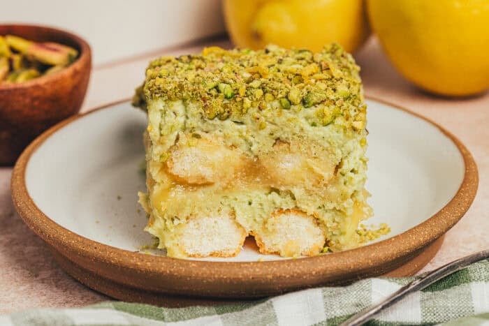 A slice of lemon pistachio tiramisu on a plate.