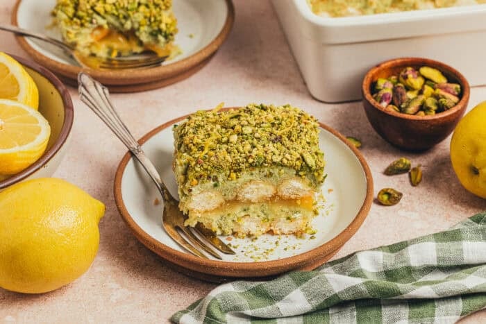 A slice of lemon pistachio tiramisu on a plate.