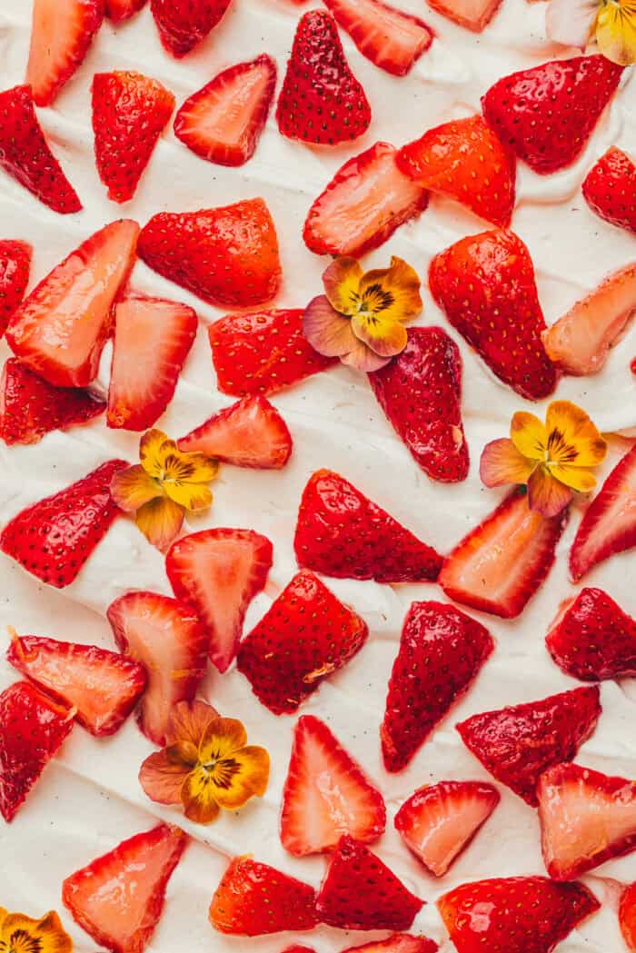 An image of the top of the cake decorated with strawberries and flowers.