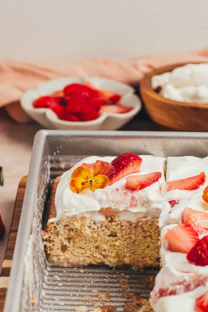 A cake pan with slices of strawberry tres leches cake.