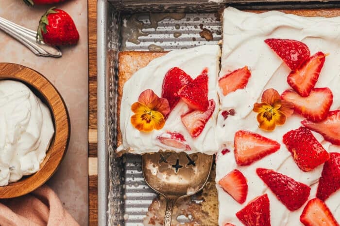 A cake pan with slices of strawberry tres leches cake.