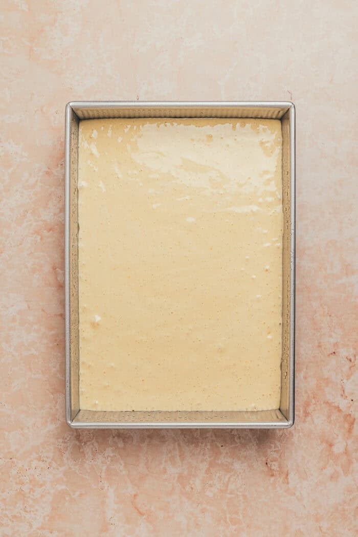 The cake batter poured into a rectangular baking dish.