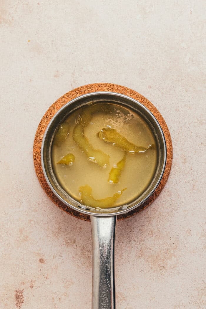 The ingredients to make the lemon syrup in a saucepan.