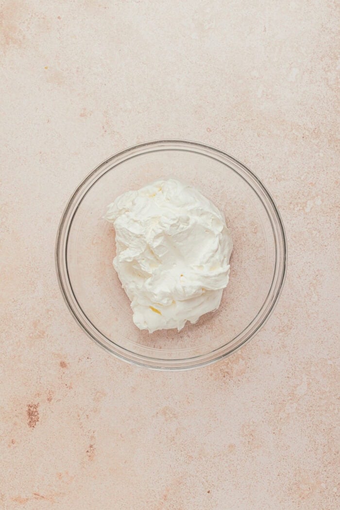 A glass bowl filled with heavy cream.