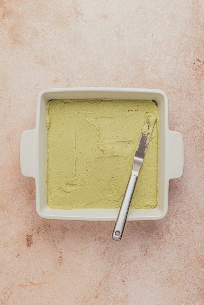 A square dish with the first layer of the lemon pistachio tiramisu.