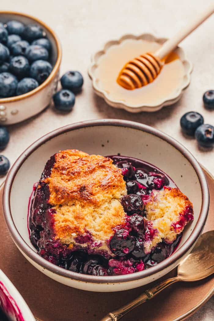 A bowl with a serving of blueberry cobbler.