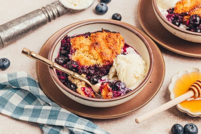 A plate with a serving of honey Sweetened blueberry cobbler.