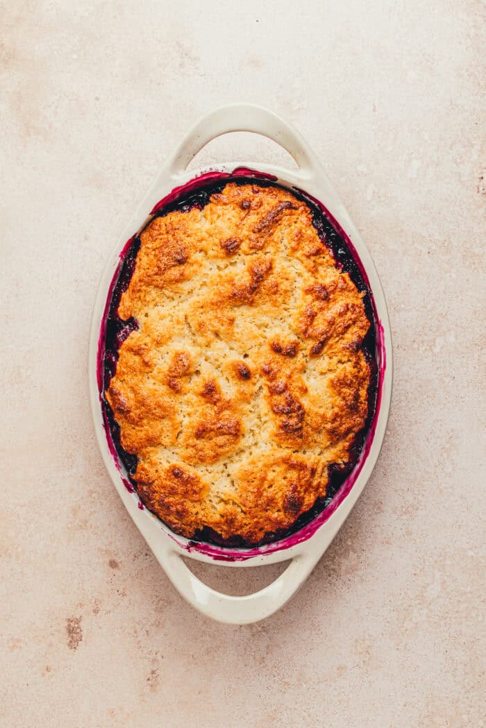 The baked blueberry cobbler in an oval baking dish.