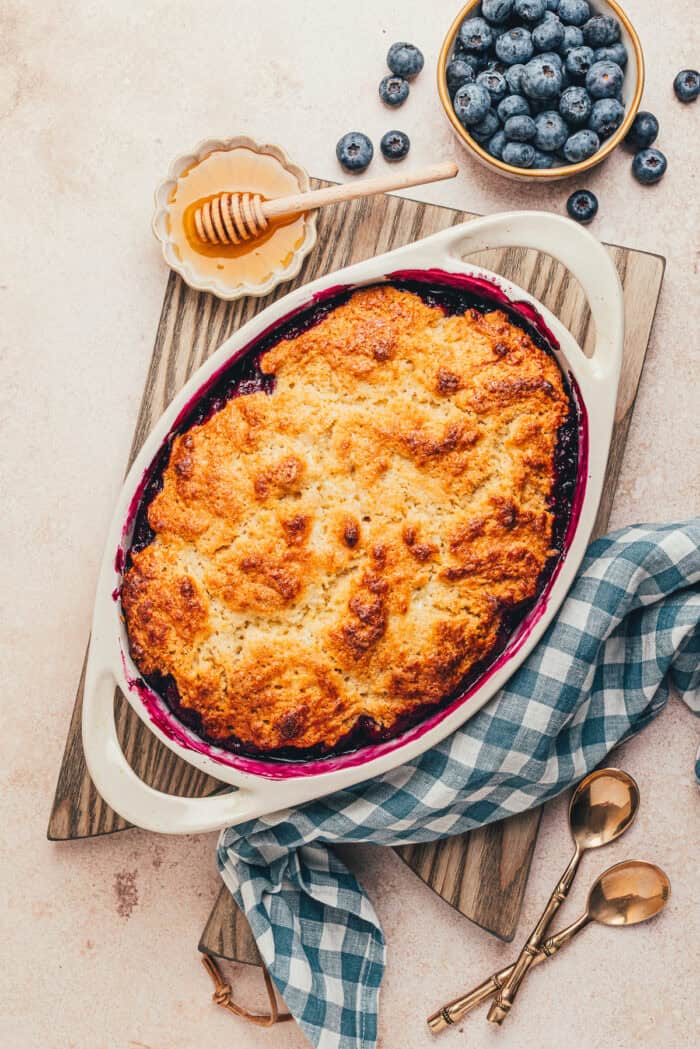 The baked blueberry cobbler in an oval baking dish.